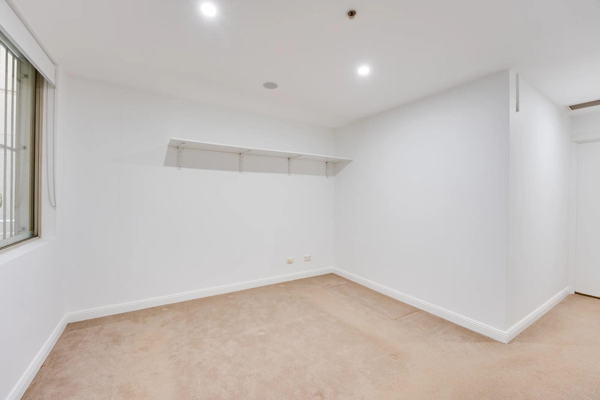 The original, unstaged listing photo. Same window, same shelf, same floor plan, staged three different ways below.