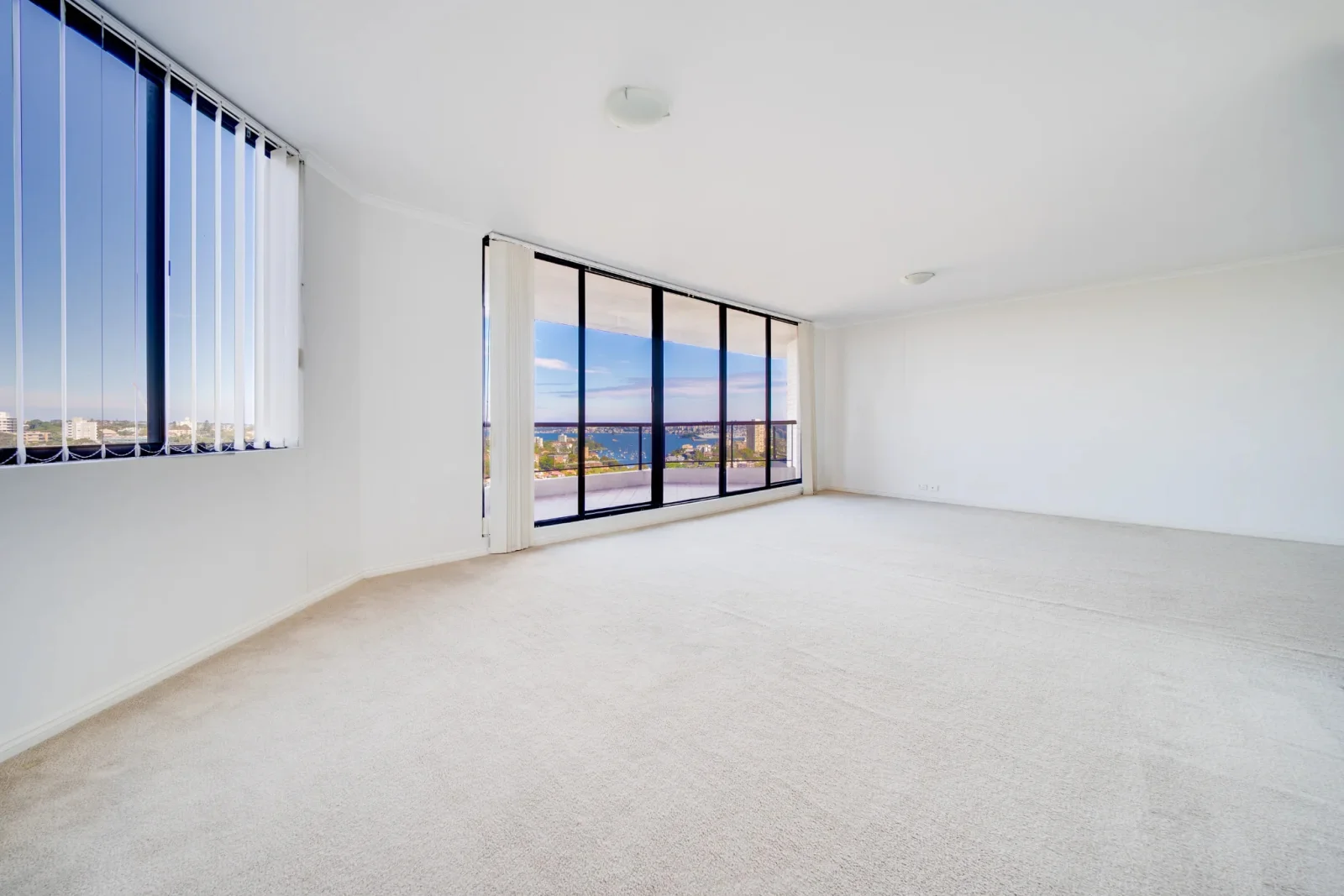 An empty, unfurnished living room straight from the camera