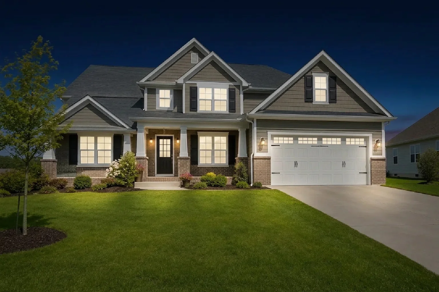 The same exterior at night: dark sky and dramatic lit windows